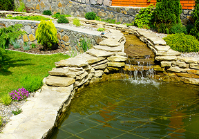An image of a beautiful drainage system, using rocks to formulate a mini-waterfall.